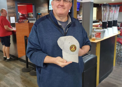 A man showing off an Atlanta Falcons cap.