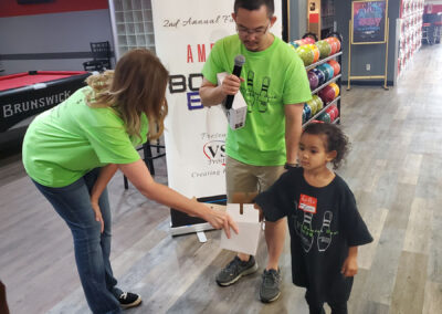 Eric with VSA holding a microphone along with a woman and a small child.