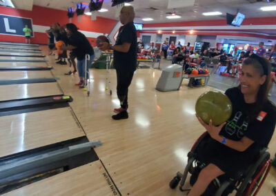 A shot of many physically handicapped people about to throw bowling balls.