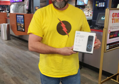 A man holding a Blink video doorbell + sync module 2.