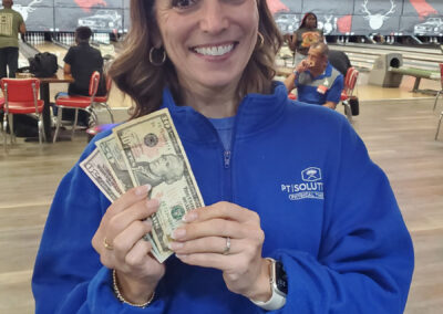 A female wearing a PT Solutions sweater showing off $70 in her hand.