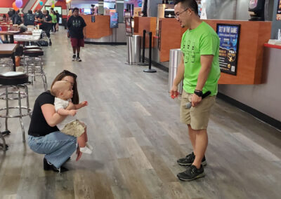 Eric with VSA Prosthetics looking down at a female holding a baby.