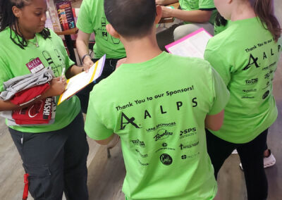 Five ALPS sponsors standing together, looking at clipboards.