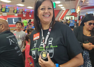 A woman smiling and holding her Runner Up medal.