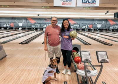 A man and a dog, both wearing prosthetics, standing by a woman from So Everybody Can Move Georgia.