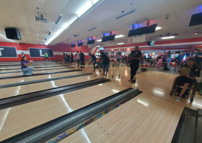 A shot of many physically handicapped people about to throw bowling balls.