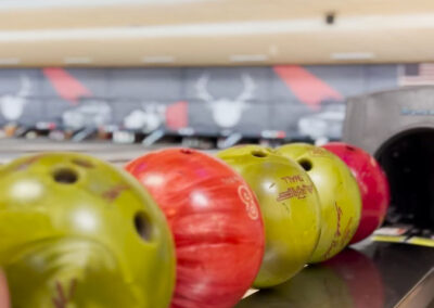 An up close shot of green and red bowling balls.