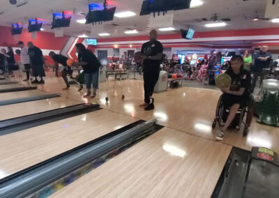 A shot of many physically handicapped people about to throw bowling balls.