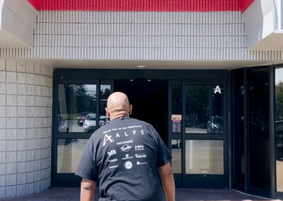 A man wearing a prosthetic leg walking into Bowlero bowling alley.